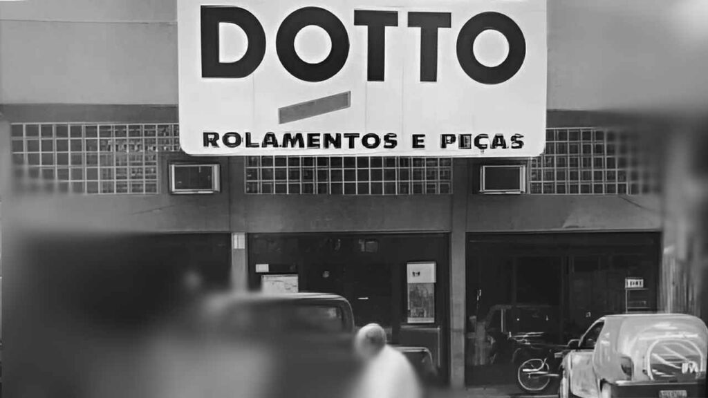 Fachada antiga de uma loja "DOTTO Rolamentos e Peças" em preto e branco. O letreiro grande e o design da fachada refletem a arquitetura de épocas passadas.