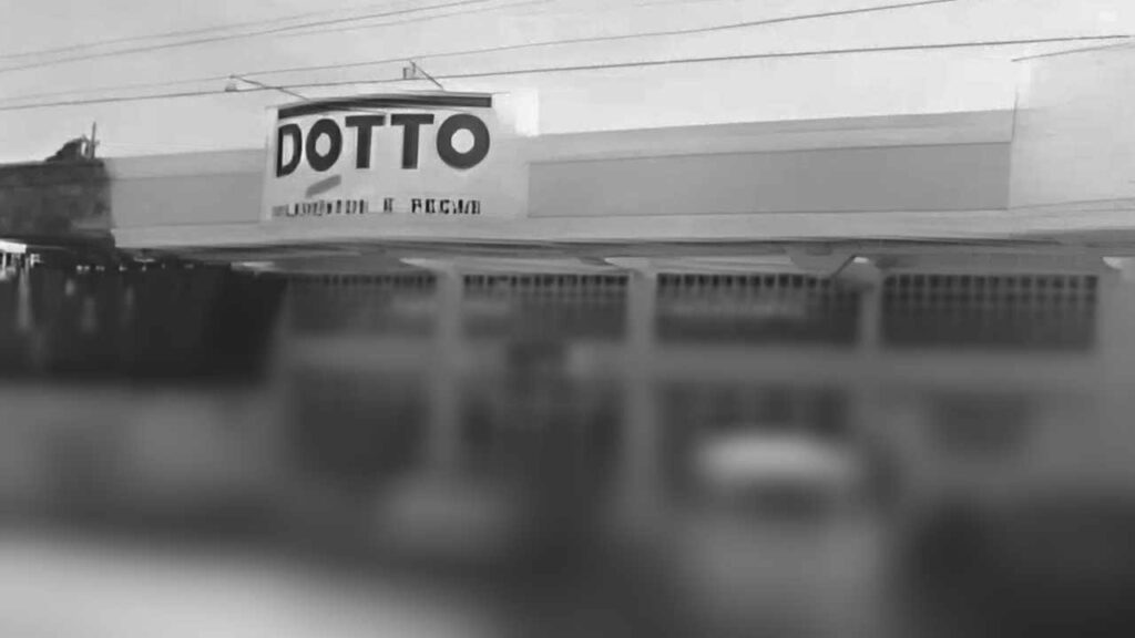 Fachada antiga da loja "DOTTO", fotografada em preto e branco. A imagem é desfocada e mostra a fachada superior com o letreiro simples.